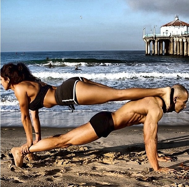 Fit couple planking on beach