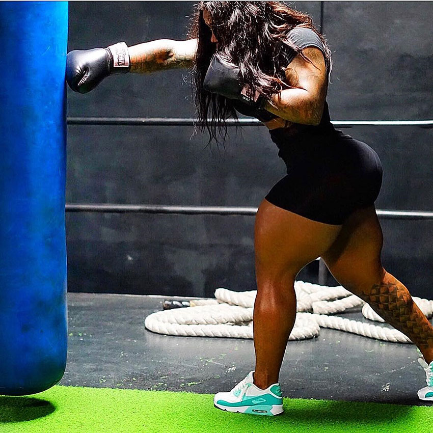 Rahki Giovanni working out with a punching bag showing how fit women are working out hard