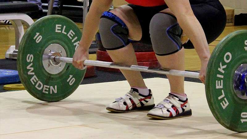 Female performing a snatch wearing weightlifting shoes