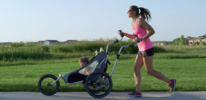 woman works out in park with jogging stroller