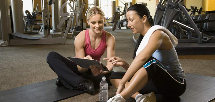 personal trainer gives feedback to female client