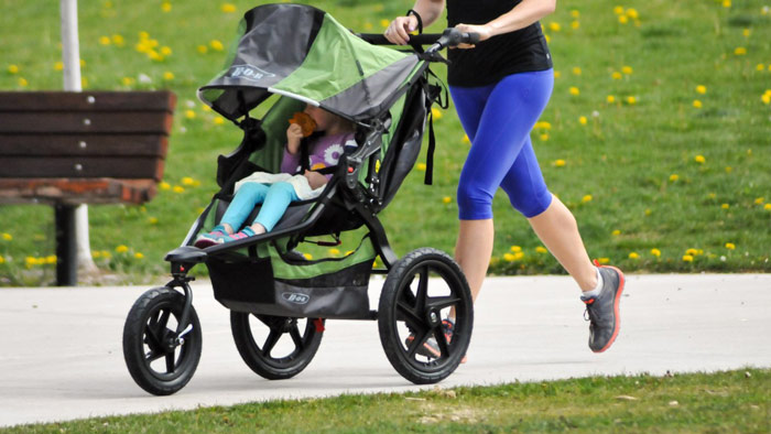 woman runs with jogging stroller