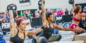 women perform crossfit kettlebell snatch 