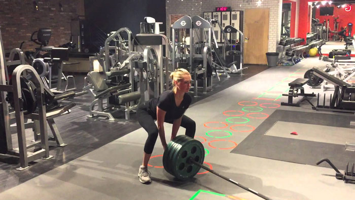 woman performs landmine deadlift for ultimate butt workout