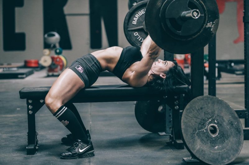 Women performing a bench press as part of her chest and shoulders workout