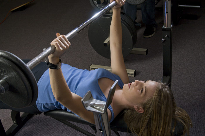 Woman at the top of a bench press movement