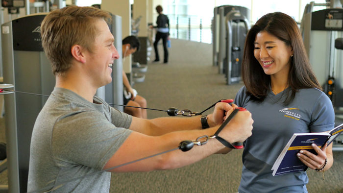 female pt training a man in the gym