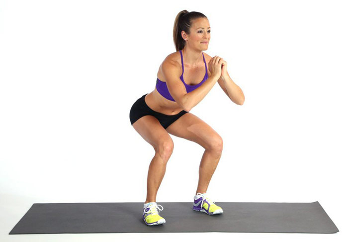 female fitness model performing the body weight squat