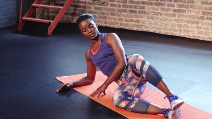 woman performing a banded clam in the gym 