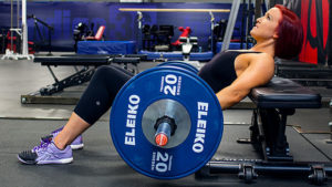 female athlete performing barbell hip thrust