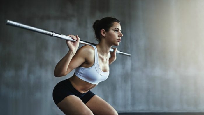 woman squatting with a barbell across her back