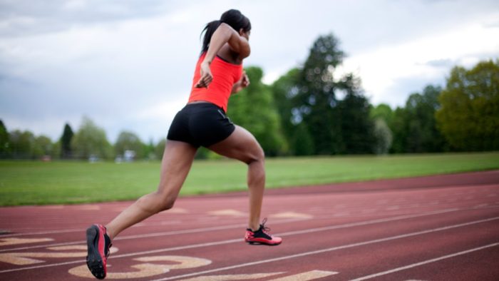 Woman sprinting as part of a how to get abs fast workout