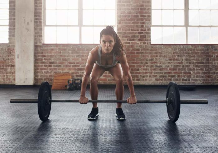 Woman at the bottom of a deadlift in a beginners fat loss workout