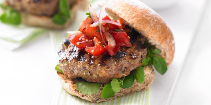 A healthy burger with brown bread and fresh peppers on top