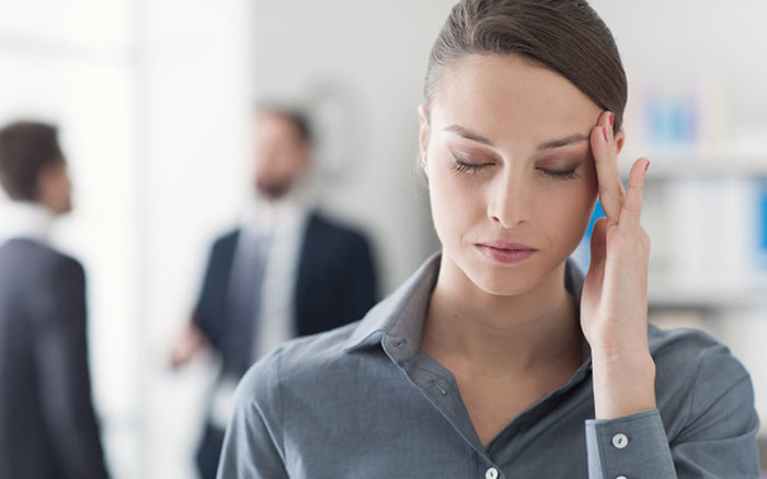 Woman holding her head to indicate she has a headache