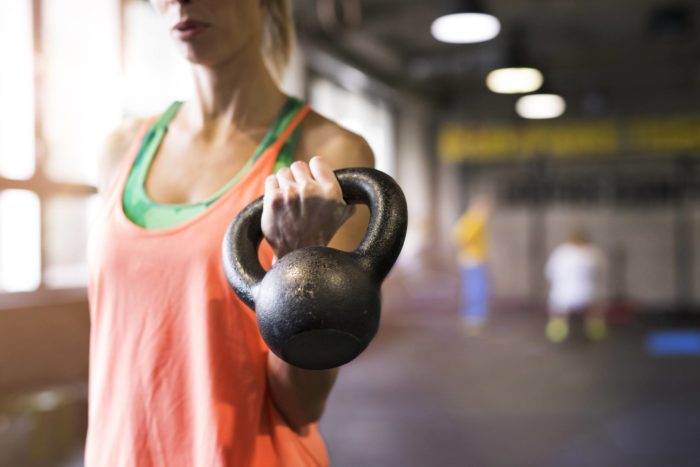 woman holding kettlebell half way through a festive kettlebell clean