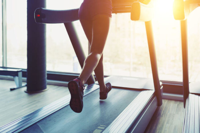 woman running on a treadmill as part of a HIIT workout 