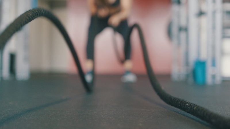 woman doing rope slams in a HIIT workout plan