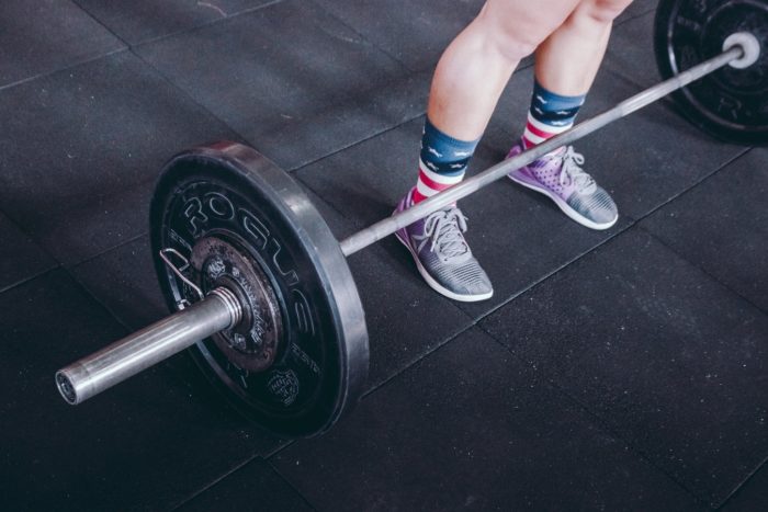 woman stood infront of a barbell about to deadlift