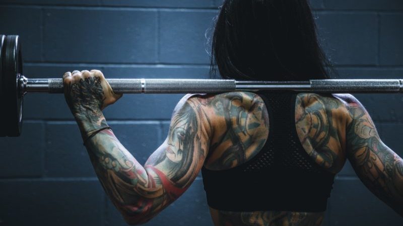 Woman with bar on her back about to squat