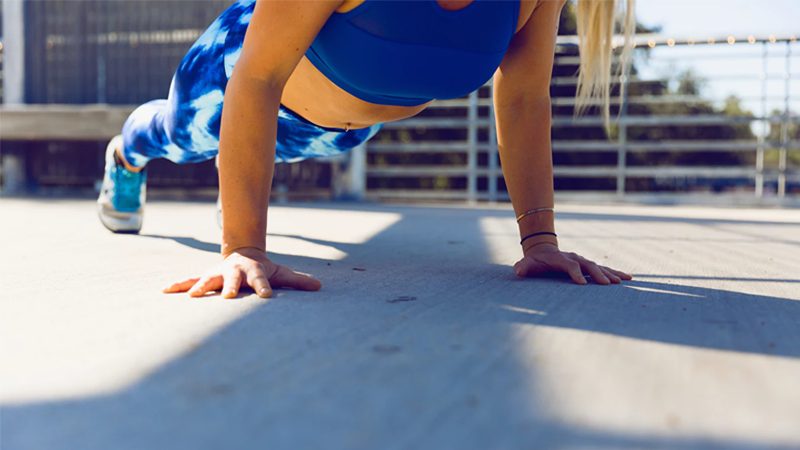 Woman performing push up strength training without weights